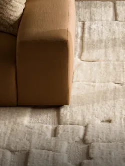 A thick wool carpet beside a leather sofa