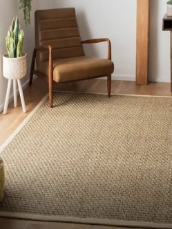 A seagrass rug beside a leather armchair