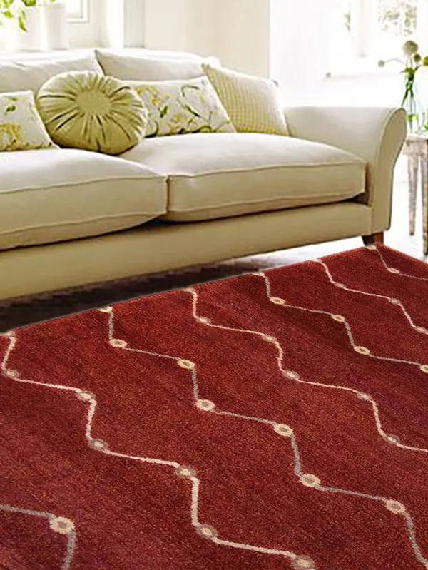 A red gabbeh carpet in front of a sofa